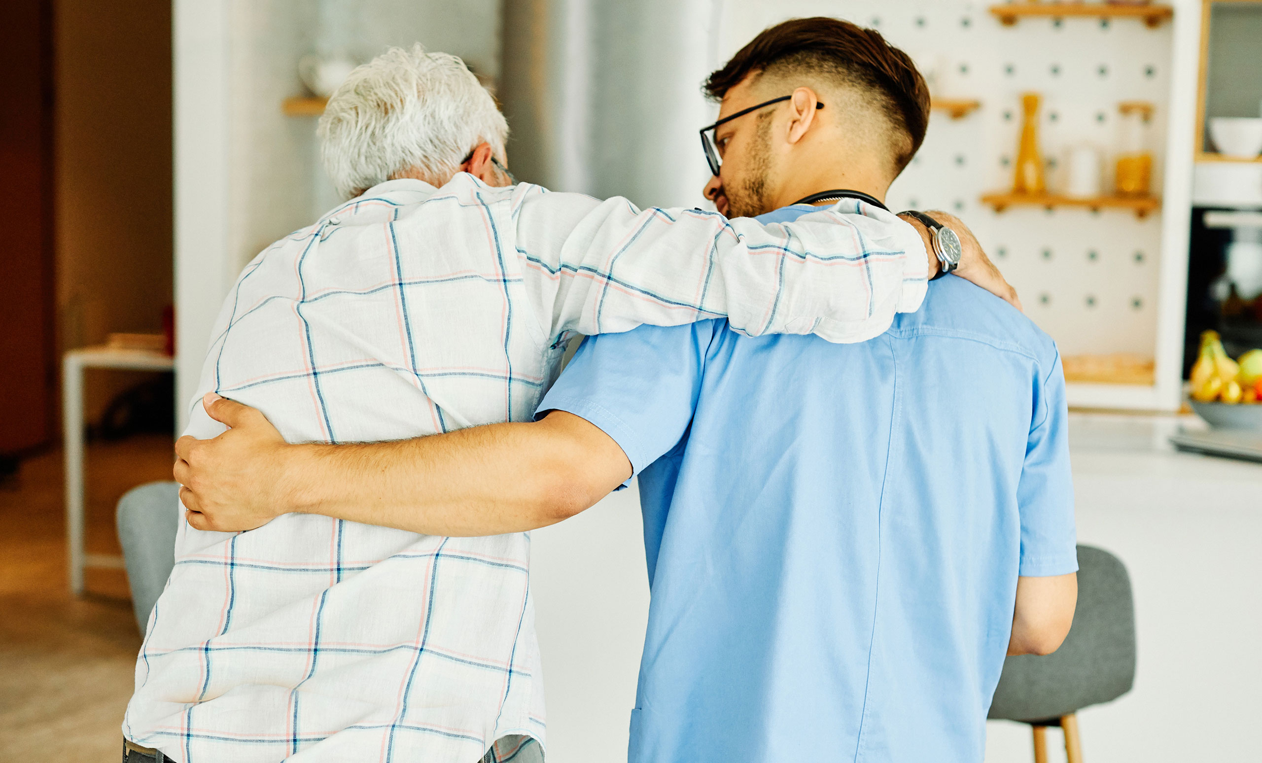 cna man helping patient stand